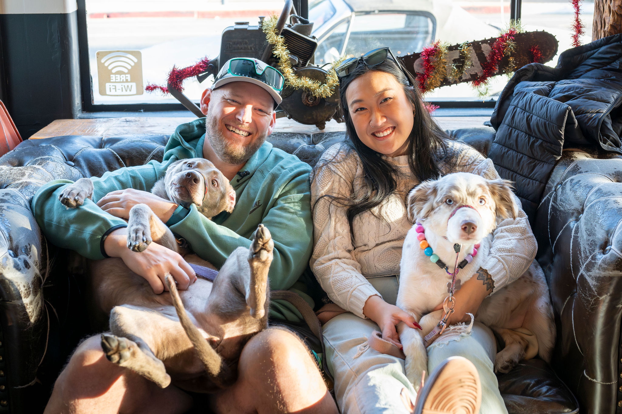 Couple sitting on a couch at Unbearable Skee Lodge with their two dogs during the holidays