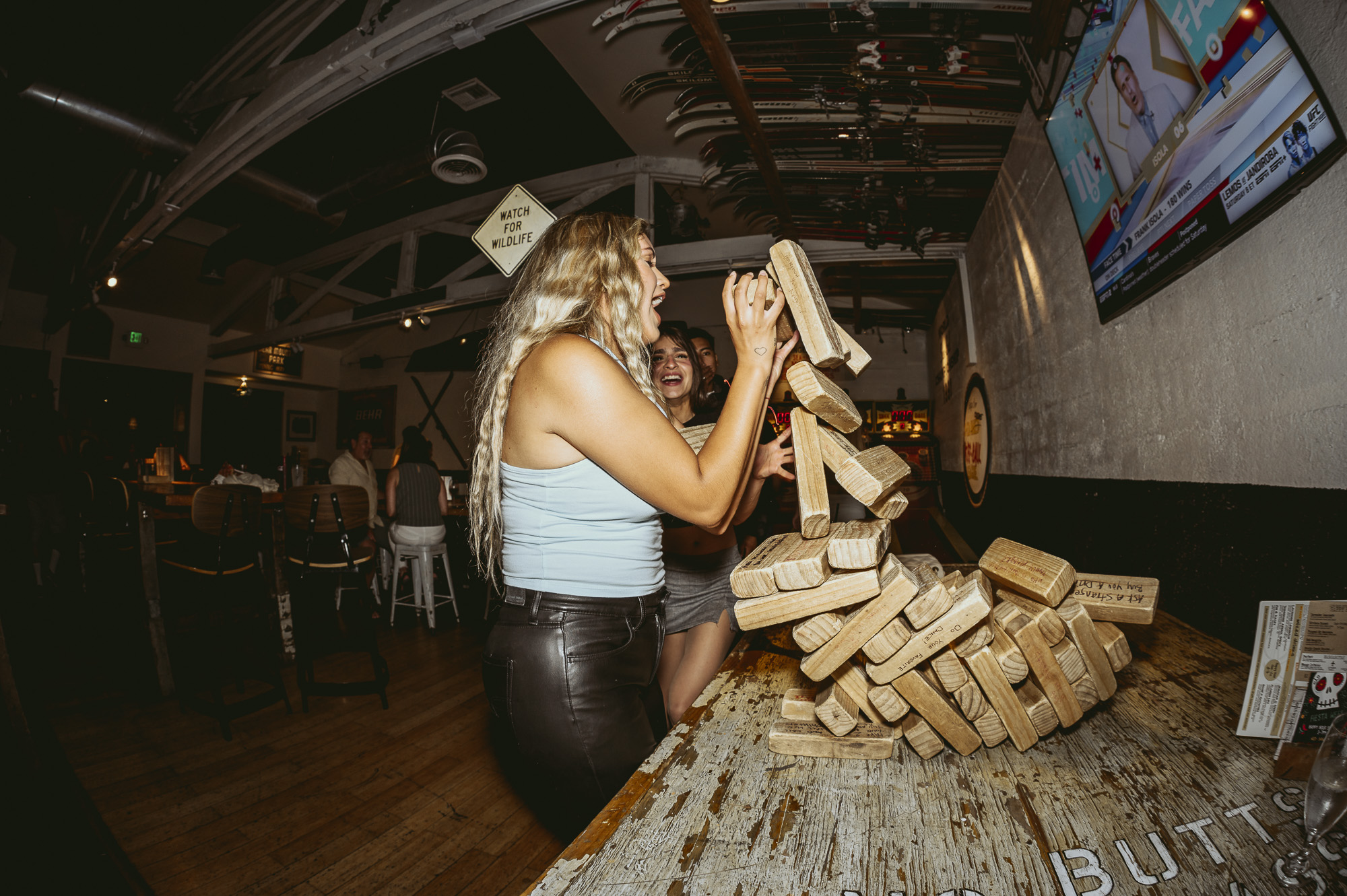 Women playing giant Jenga at Unbearable Skee Lodge during a party event