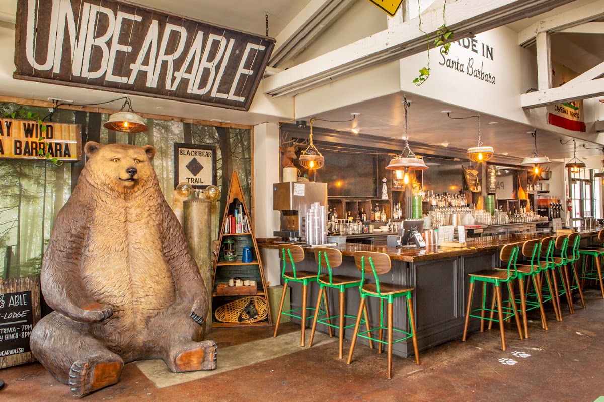 Interior of Unbearable Skee Lodge showing the bar with green stools and the iconic bear statue